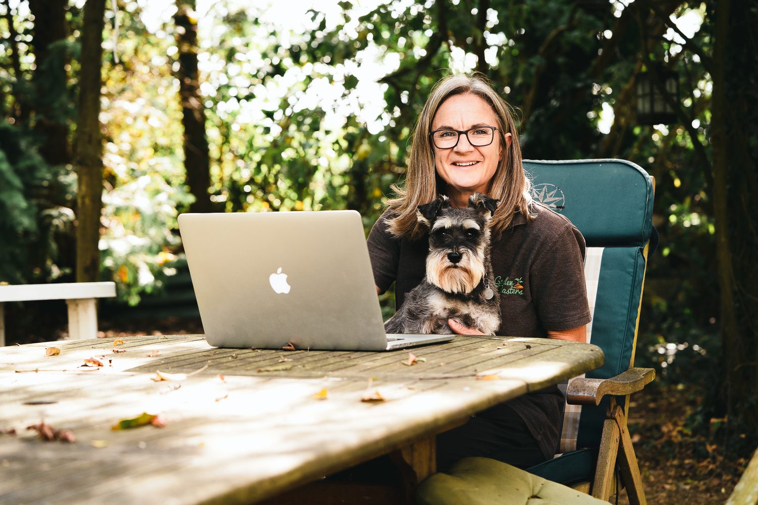 Business owner with her dog and laptop in the garden, Surrey brand photography