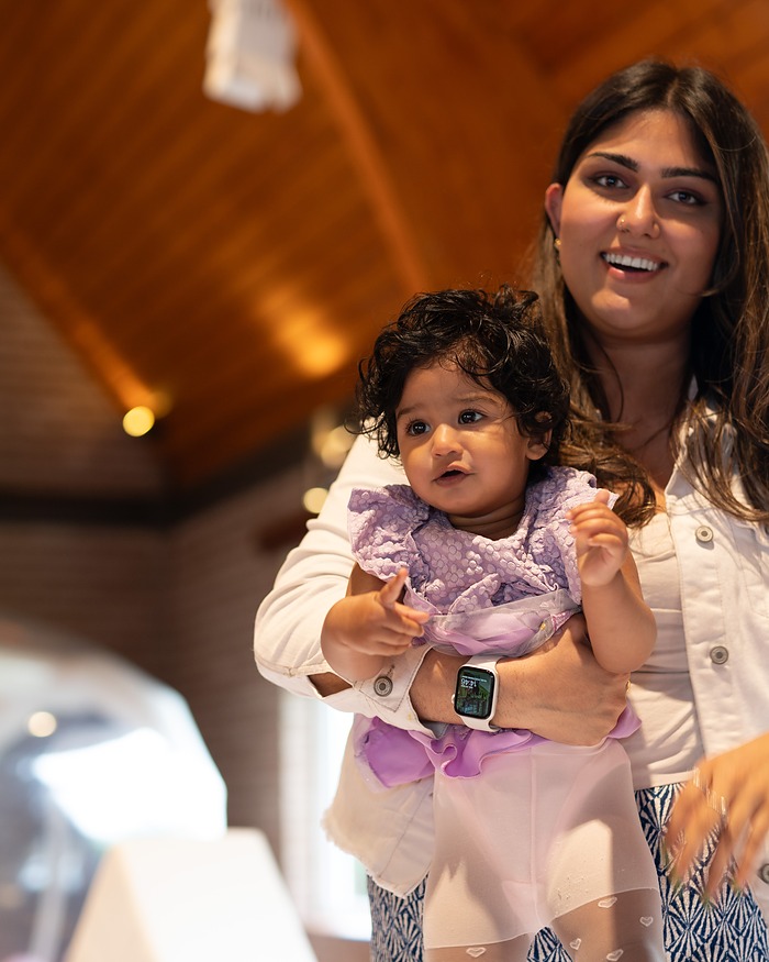 Mother holding her baby at a family celebration