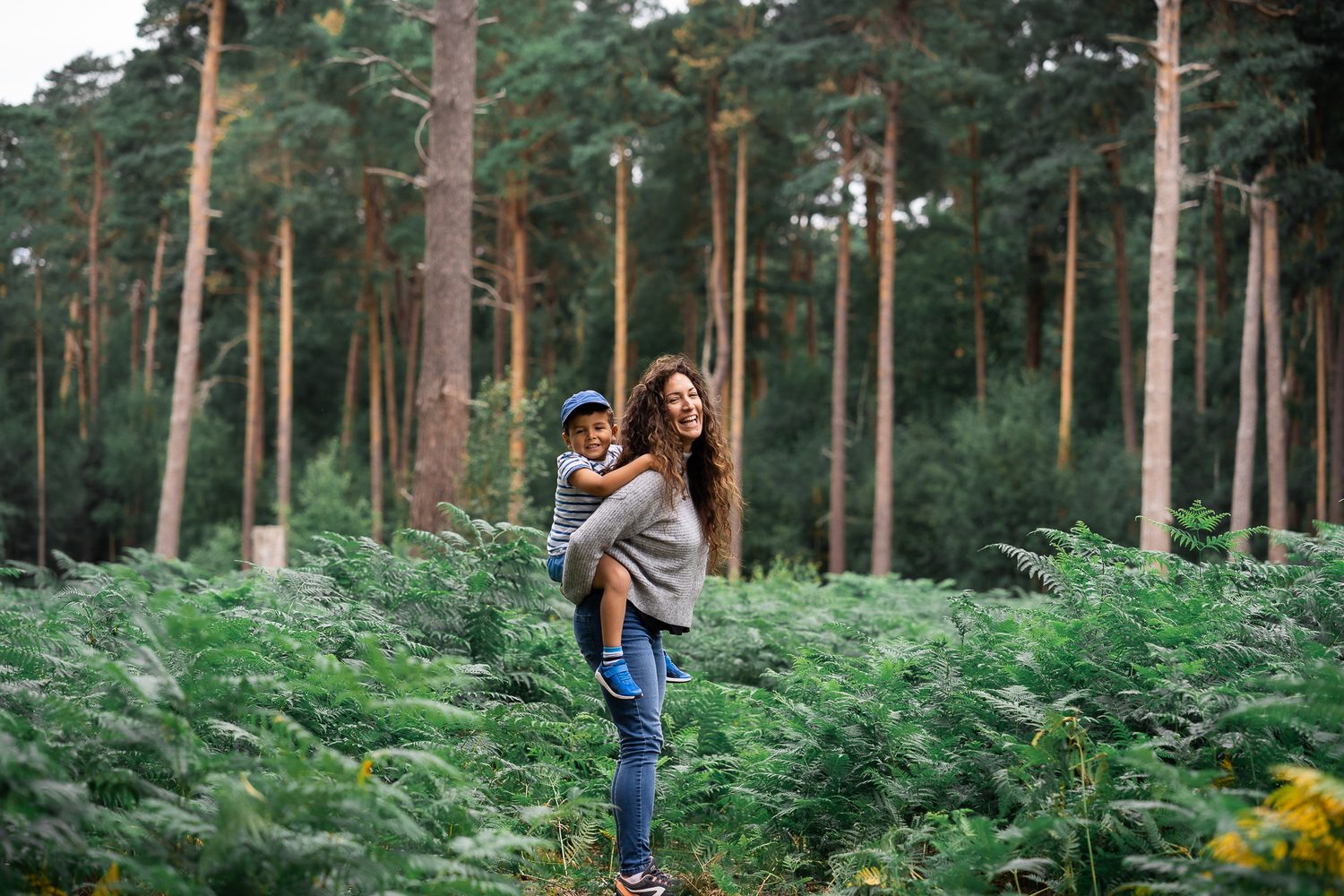 Family piggyback walk through a Surrey wood