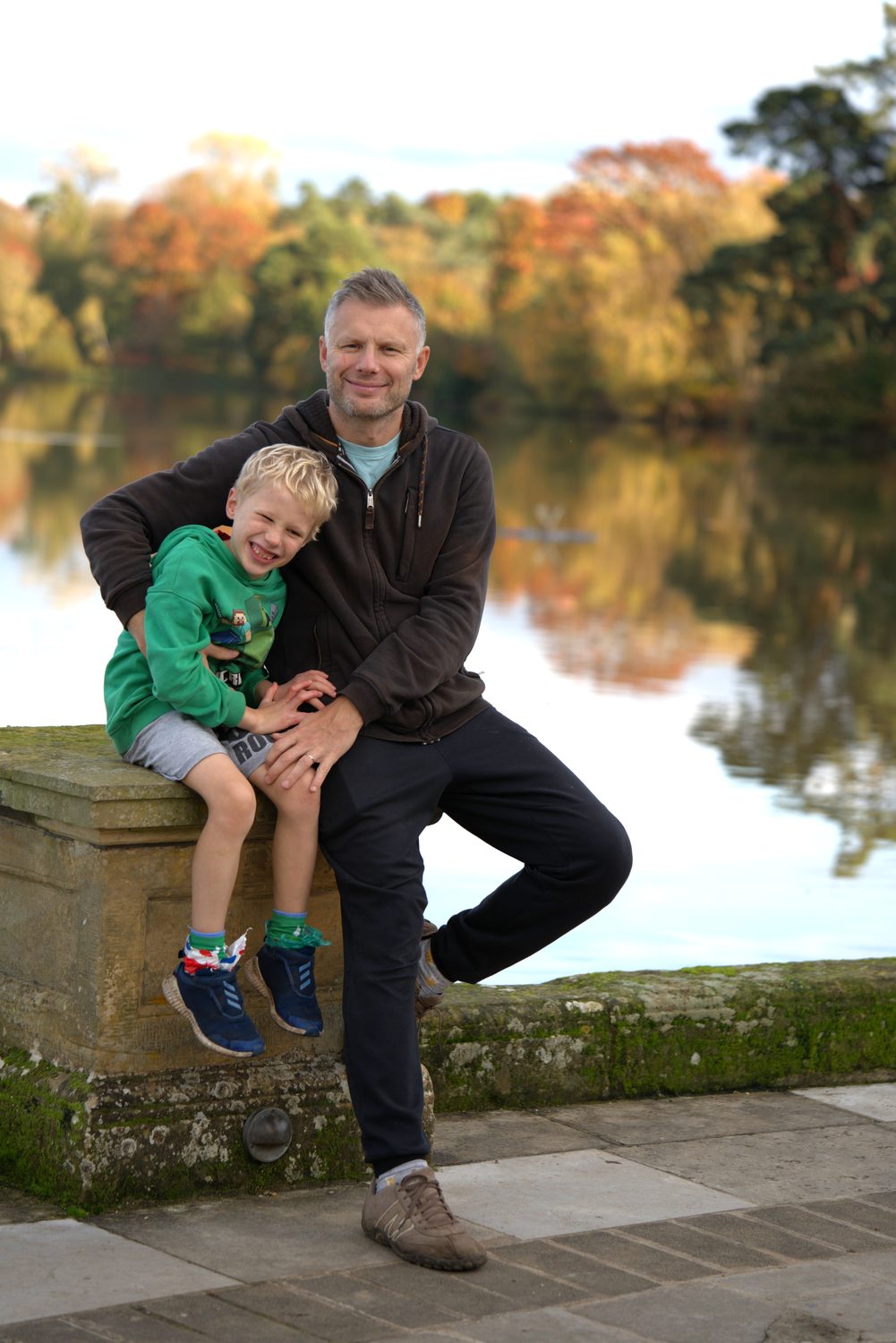 Father and son by the lake among autumn colour on a Surrey family photoshoot