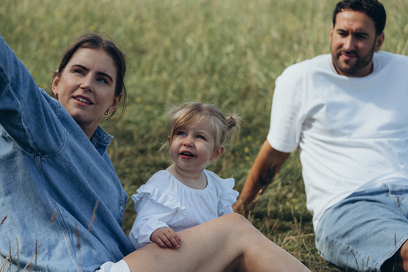 Family sitting on the grass together on a summer afternoon