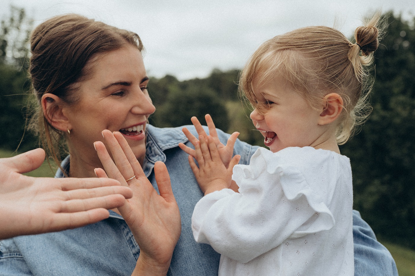 Mother and toddler playing a clapping game face to face