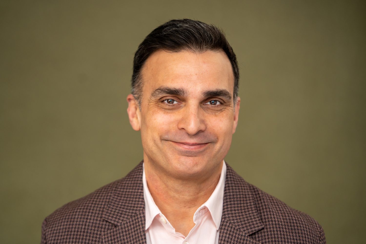 Corporate headshot of a man on a green background, Surrey