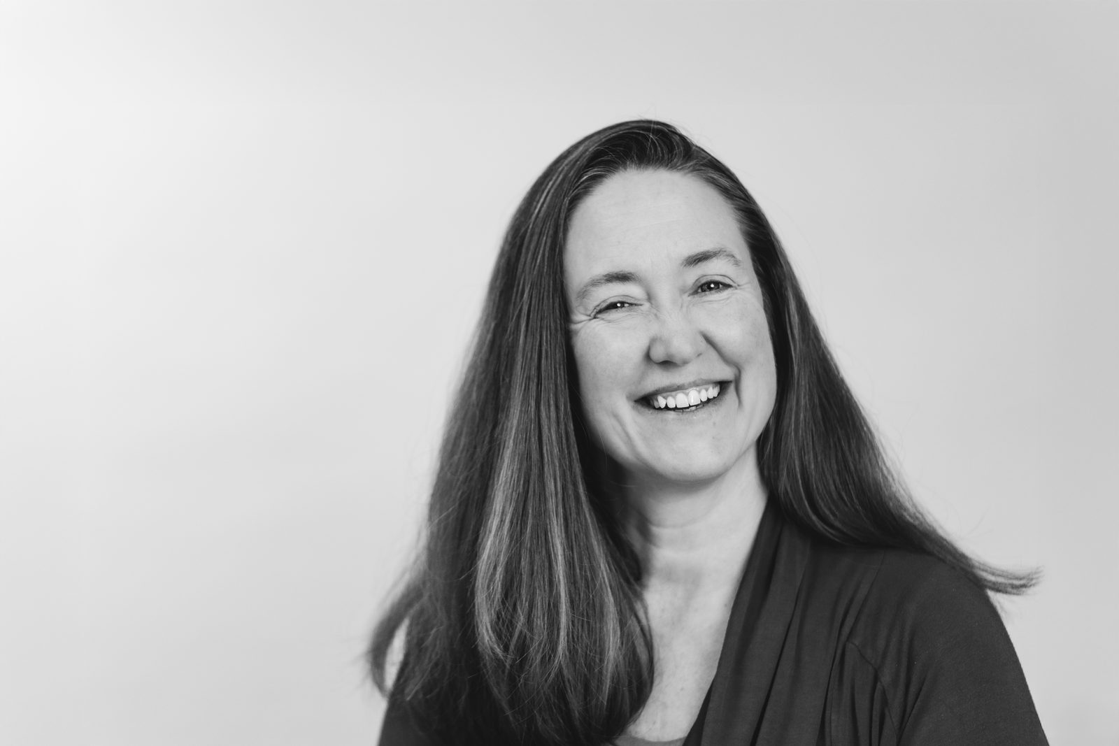 Black and white headshot of a woman laughing