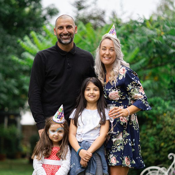 Family in party hats at a garden birthday