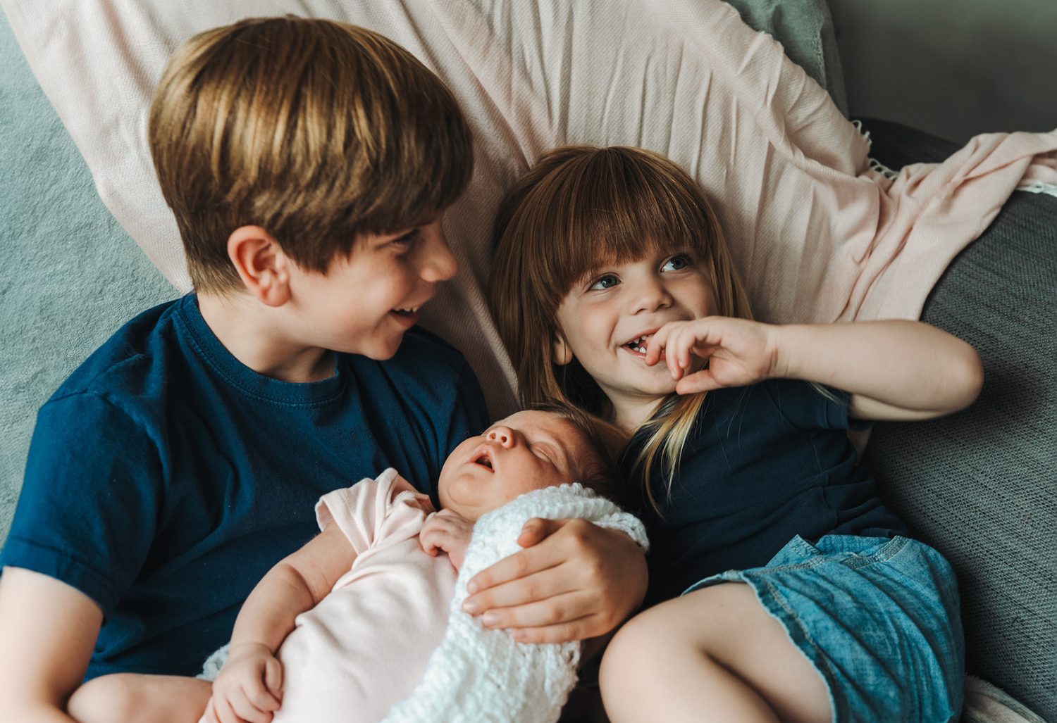 Siblings meeting their newborn baby at home in Surrey