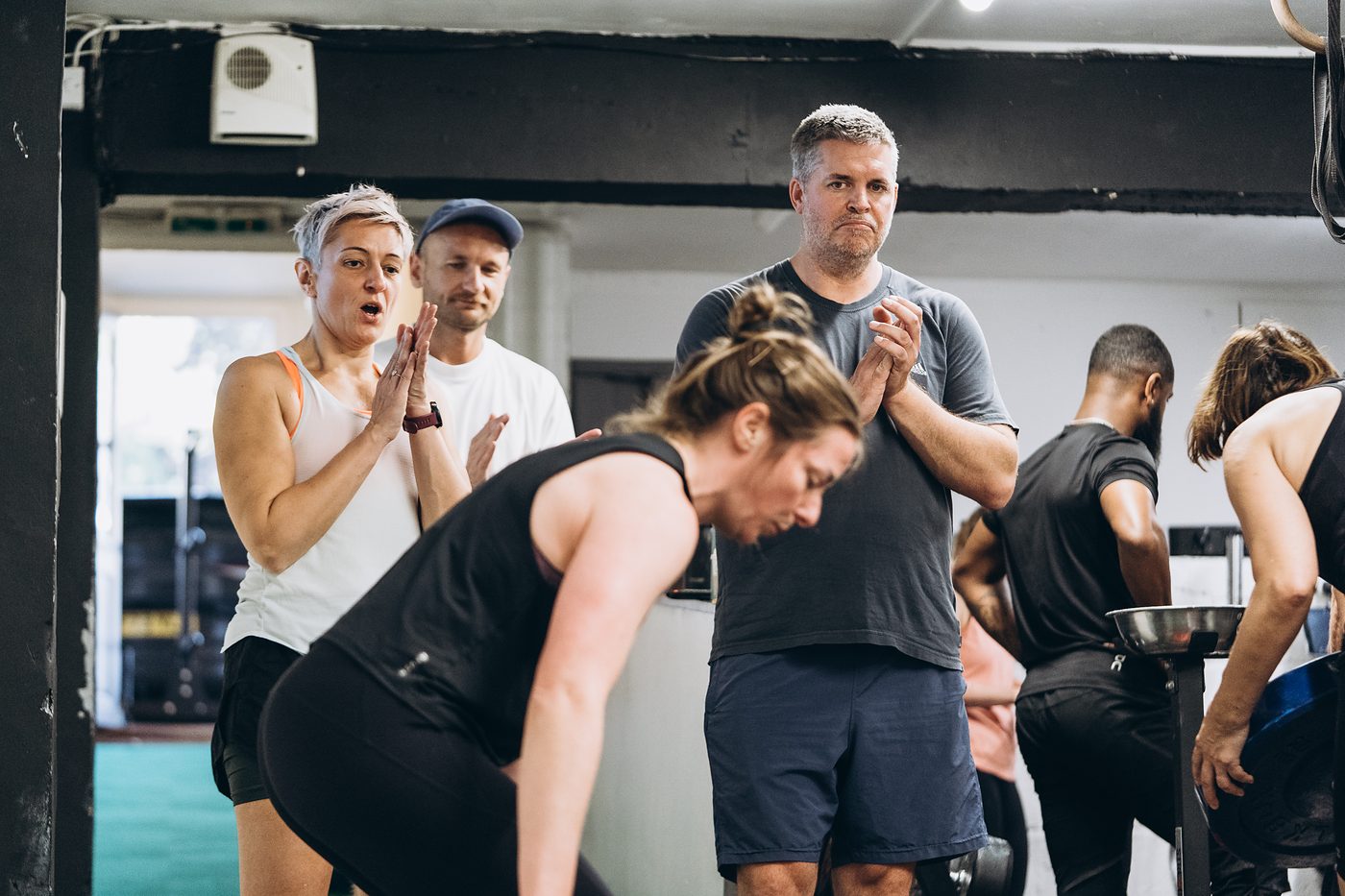 Teammates clapping as a woman finishes her lift