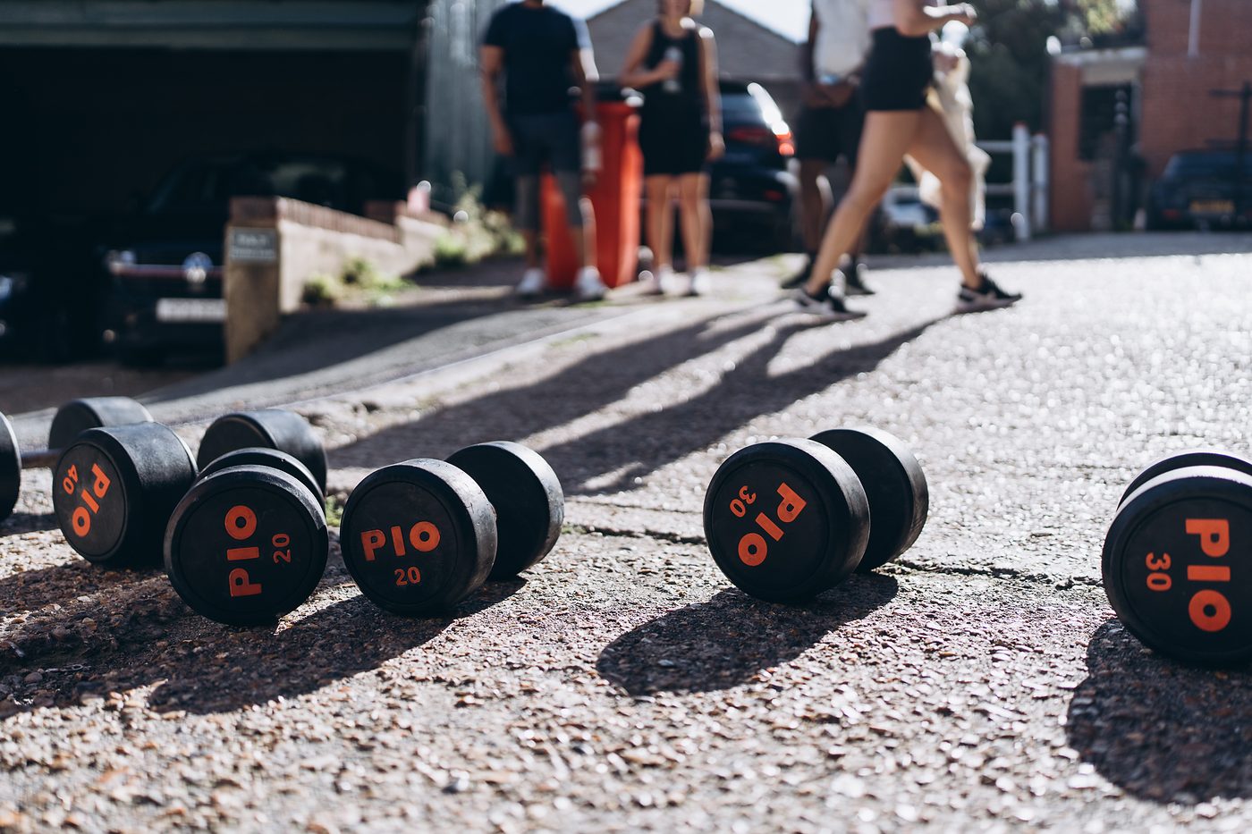 Dumbbells lined up on the tarmac outside the gym for the farmers carry