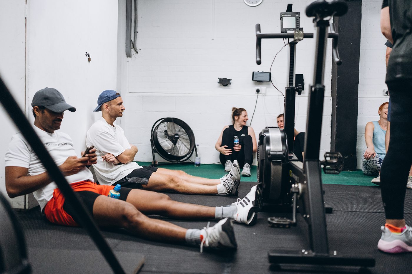 Members sitting on the gym floor getting their breath back after the last round