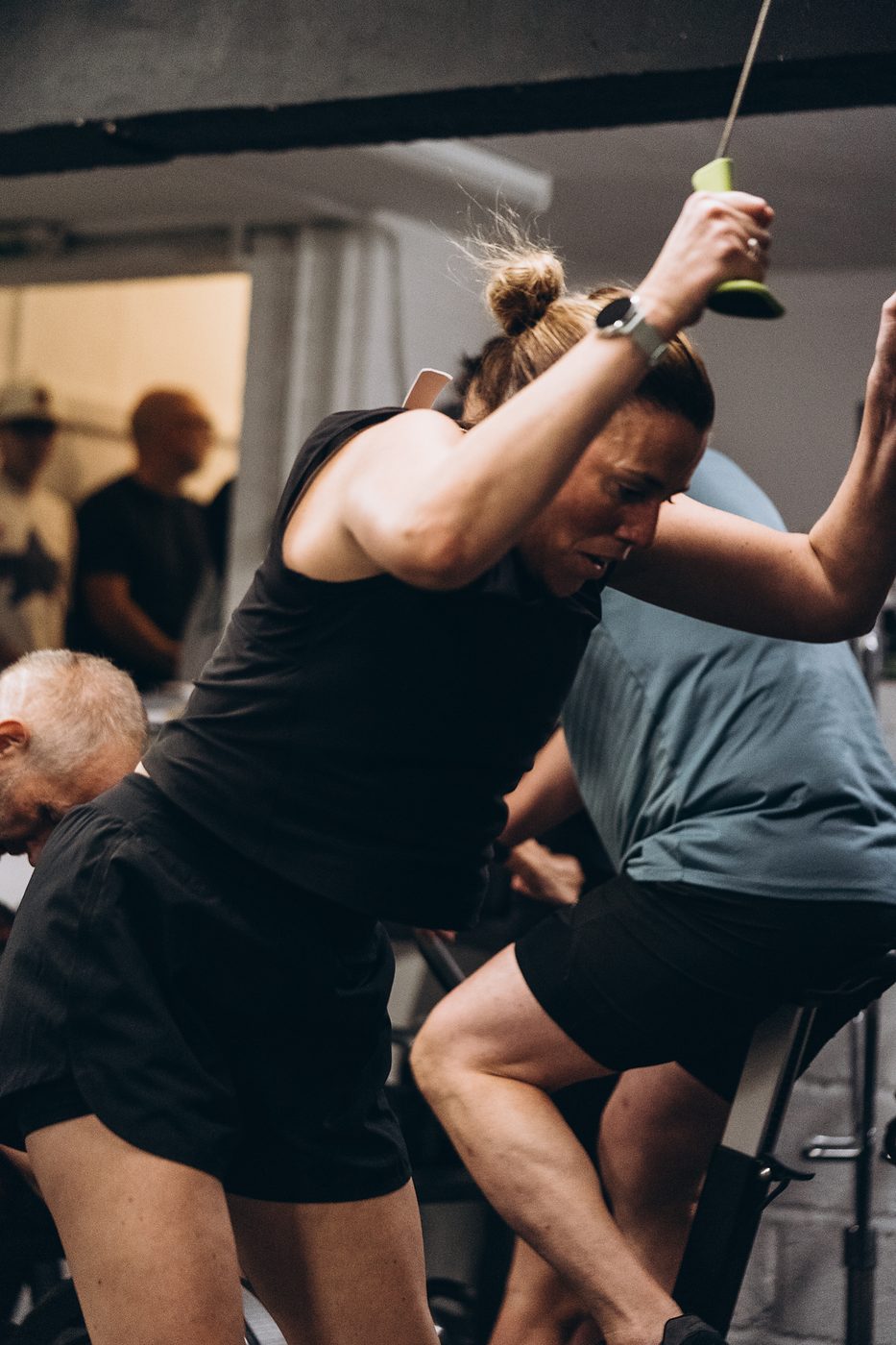 Woman pulling hard on a SkiErg during the cardio round