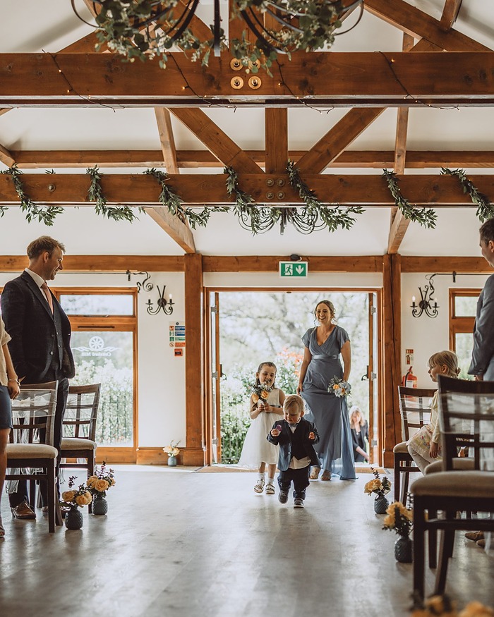 Wedding ceremony at a Surrey barn, children walking down the aisle