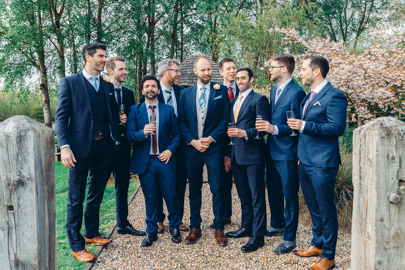 Groom and his groomsmen in navy suits laughing together outside