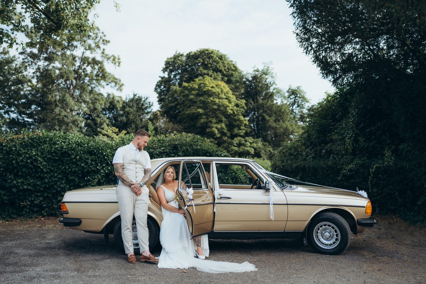 Bride and groom with a vintage car at a Surrey wedding
