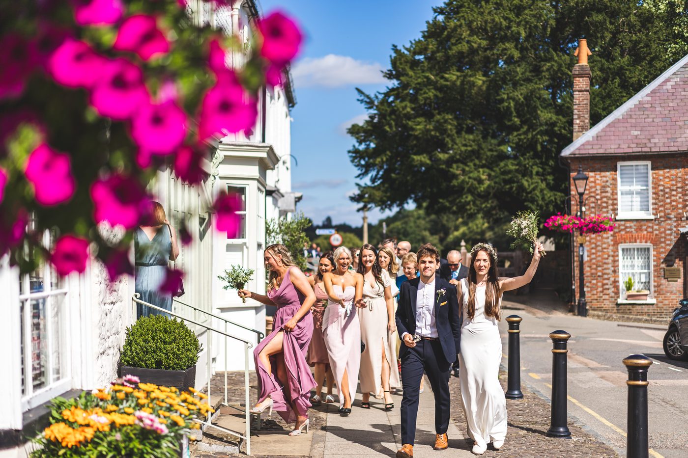 Wedding party walking through a Surrey village