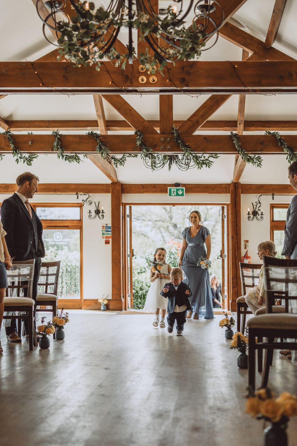 Wedding ceremony at a Surrey barn venue, children walking down the aisle